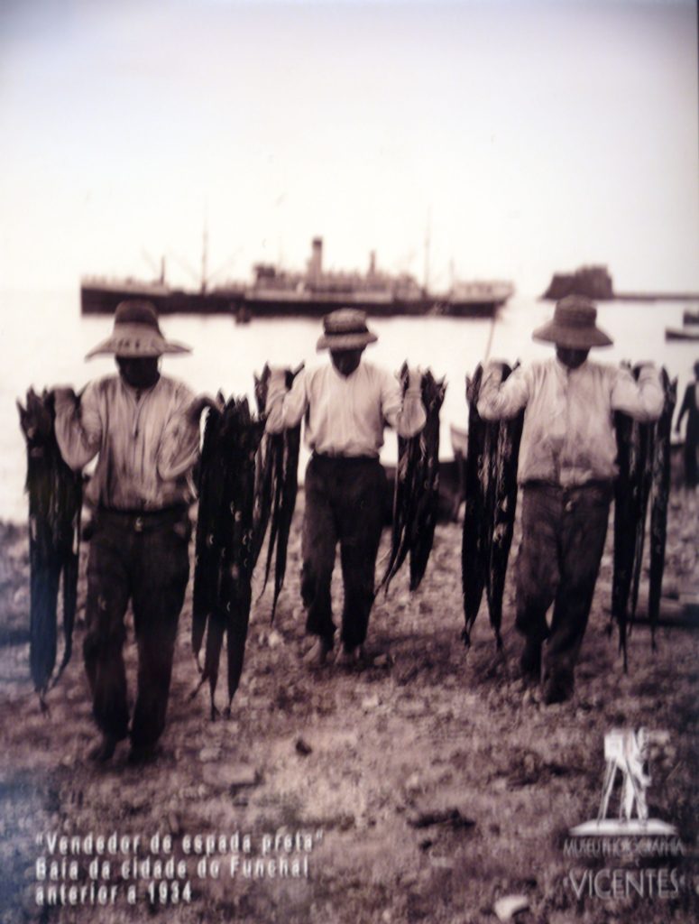 Fishermen in Funchal carrying a catch of espada